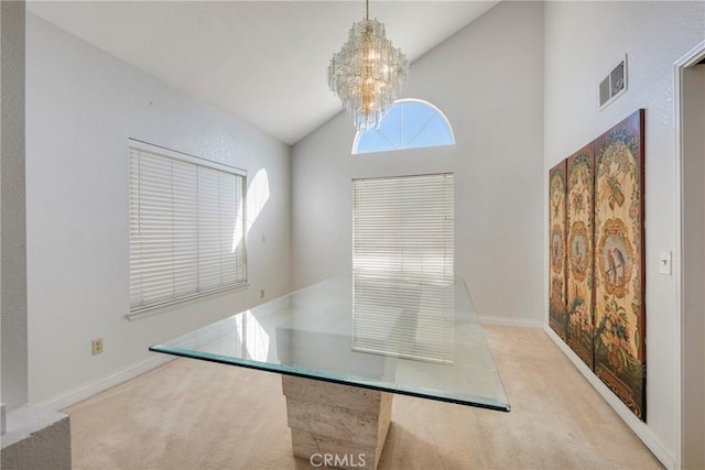 unfurnished dining area featuring high vaulted ceiling, light carpet, and an inviting chandelier