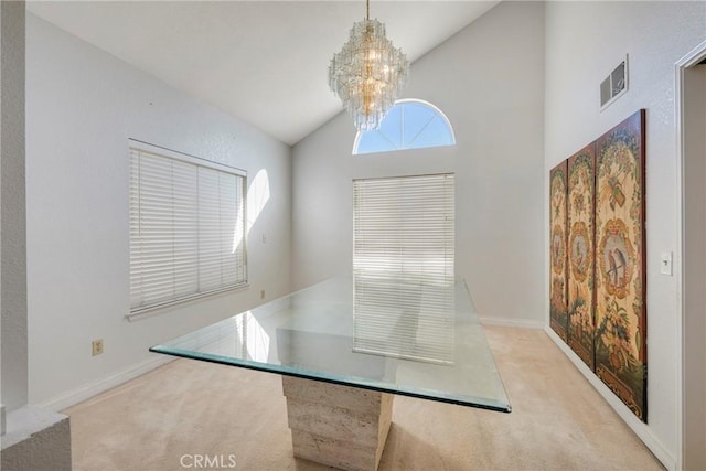 unfurnished dining area with light carpet, high vaulted ceiling, baseboards, and an inviting chandelier