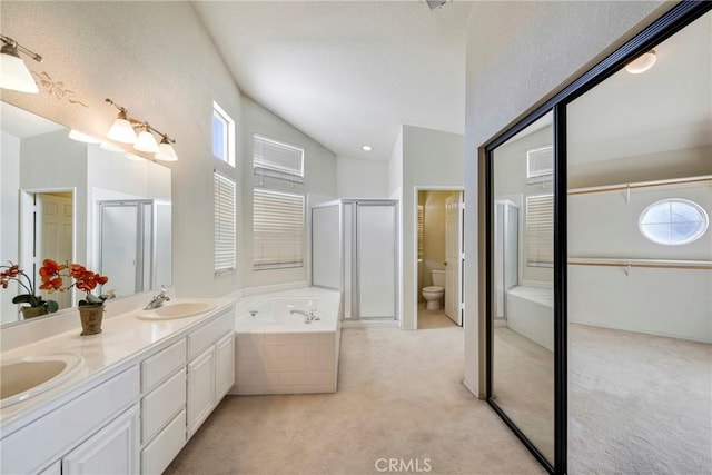 full bathroom with vaulted ceiling, shower with separate bathtub, vanity, and toilet