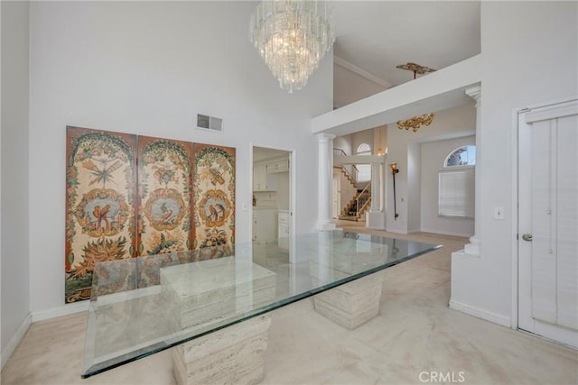 unfurnished dining area featuring a notable chandelier, a towering ceiling, and light colored carpet