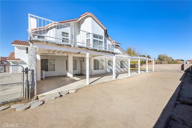 rear view of property with a balcony and a patio