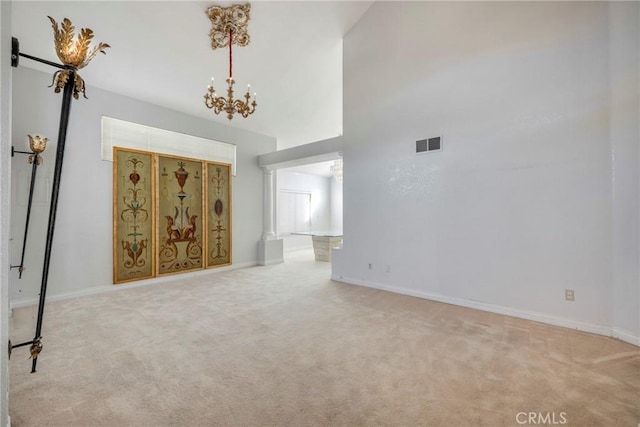 unfurnished living room with baseboards, visible vents, a chandelier, and light colored carpet