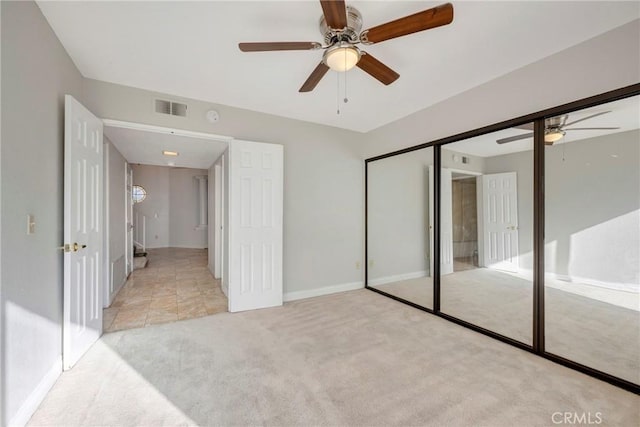 unfurnished bedroom featuring light colored carpet, ceiling fan, and a closet