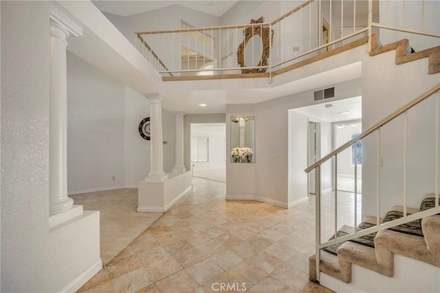 foyer entrance featuring a high ceiling and ornate columns