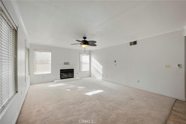 unfurnished living room with crown molding, light colored carpet, and ceiling fan