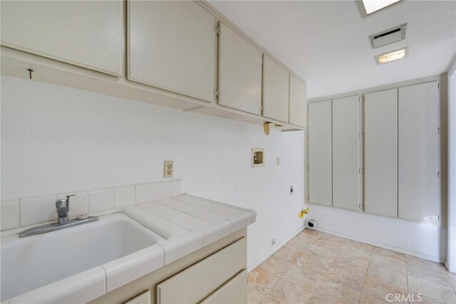 laundry room with washer hookup, sink, cabinets, and hookup for an electric dryer