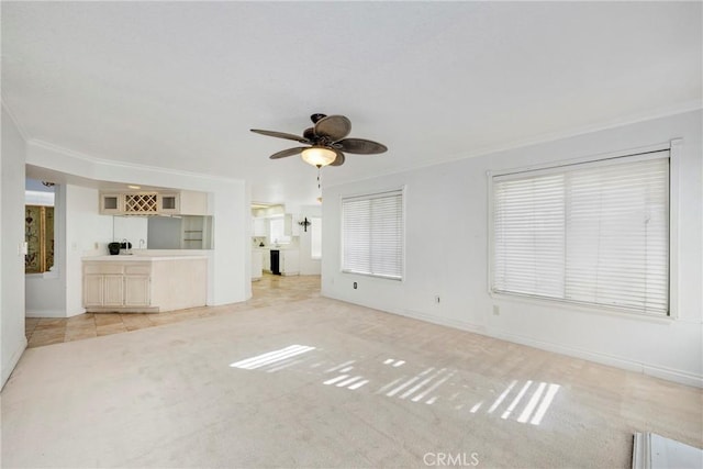 unfurnished living room with crown molding, light carpet, and ceiling fan