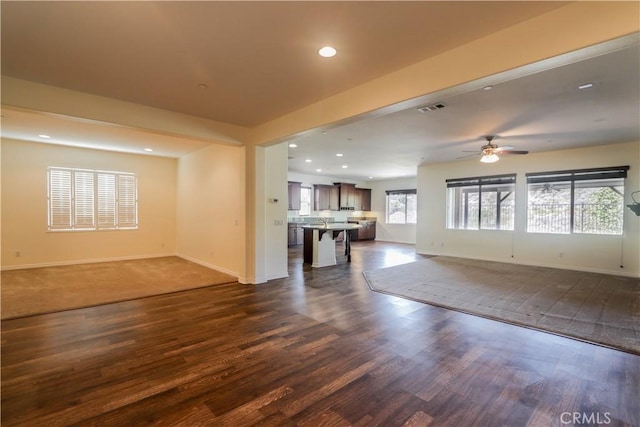 unfurnished living room featuring dark hardwood / wood-style floors and ceiling fan