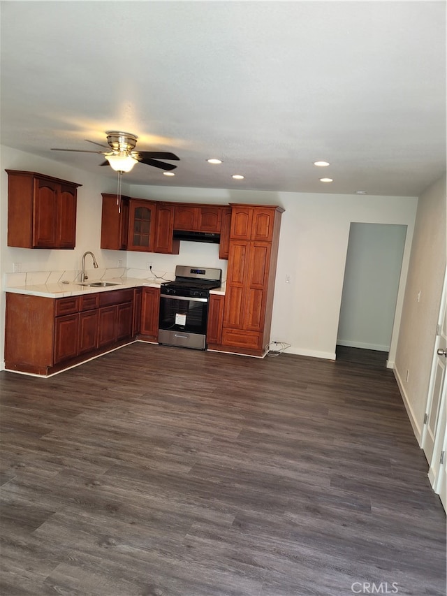 kitchen featuring dark wood-type flooring, ceiling fan, sink, and stainless steel range