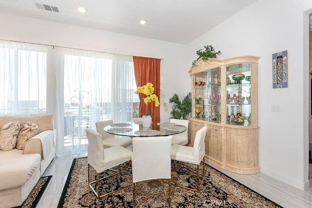 dining room featuring hardwood / wood-style flooring, a wealth of natural light, and vaulted ceiling