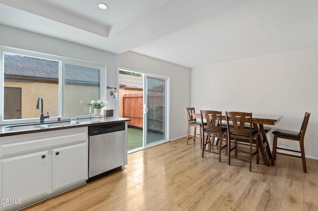 kitchen featuring white cabinets, light wood-type flooring, sink, and stainless steel dishwasher