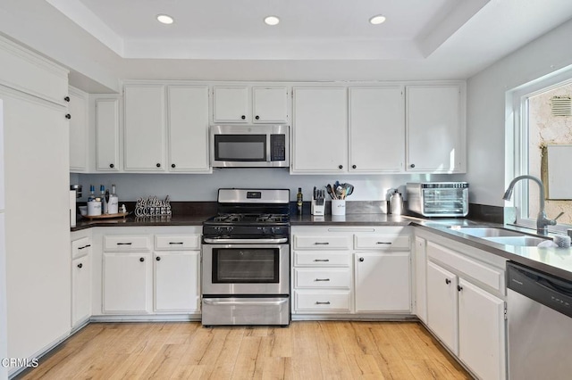 kitchen featuring light hardwood / wood-style floors, sink, stainless steel appliances, and white cabinets