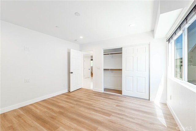 unfurnished bedroom with a closet and light hardwood / wood-style flooring