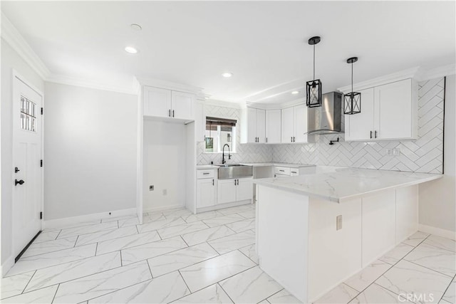 kitchen with pendant lighting, wall chimney exhaust hood, white cabinetry, and kitchen peninsula