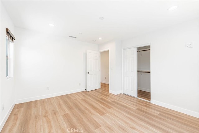 unfurnished bedroom featuring light hardwood / wood-style floors and a closet