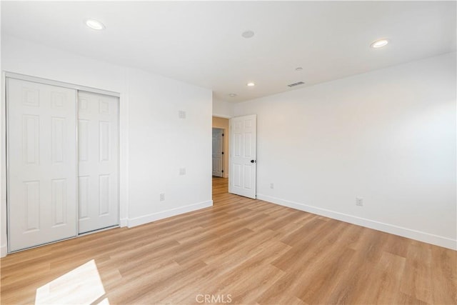 unfurnished bedroom featuring a closet and light hardwood / wood-style flooring