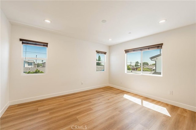 spare room featuring a wealth of natural light and light wood-type flooring