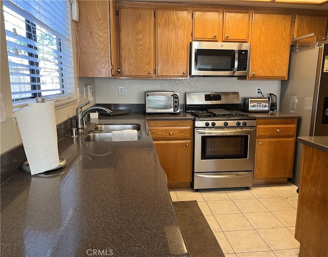 kitchen with sink, light tile patterned floors, and stainless steel appliances