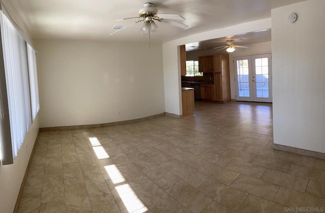 unfurnished living room featuring ceiling fan and french doors