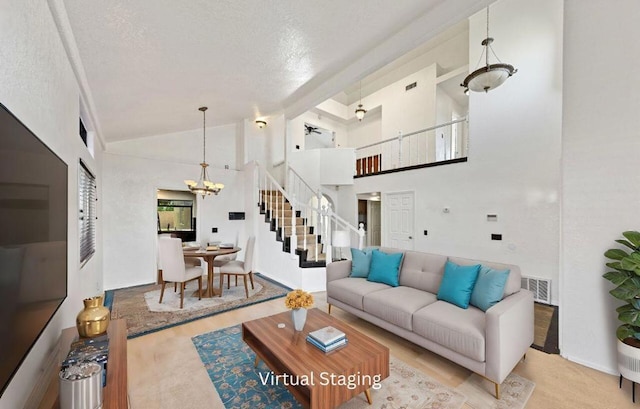 living room featuring a textured ceiling, light colored carpet, high vaulted ceiling, and a notable chandelier