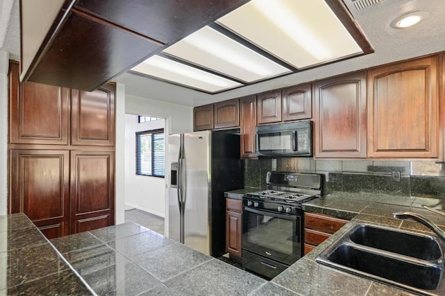 kitchen featuring tasteful backsplash, sink, and black appliances