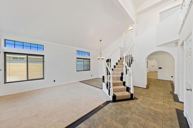 tiled foyer entrance with an inviting chandelier, plenty of natural light, and high vaulted ceiling