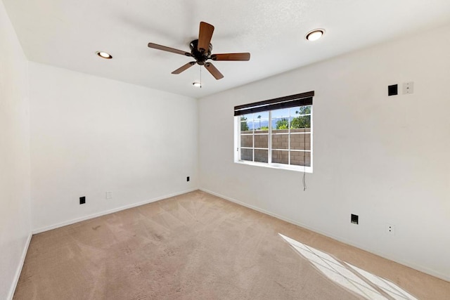 empty room featuring light colored carpet and ceiling fan