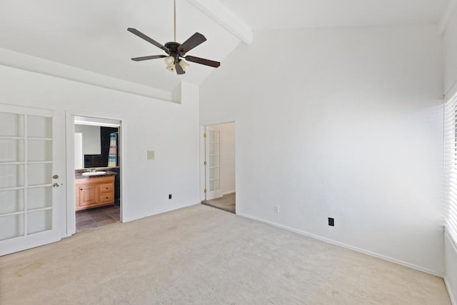 unfurnished bedroom featuring connected bathroom, high vaulted ceiling, beam ceiling, and light colored carpet