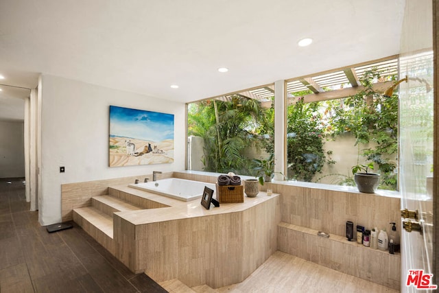 bathroom featuring a bathing tub, plenty of natural light, and hardwood / wood-style flooring