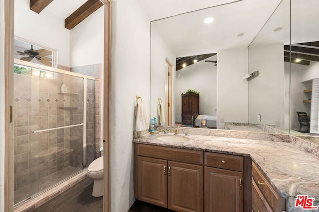 bathroom featuring ceiling fan, wood-type flooring, toilet, a shower with door, and vanity