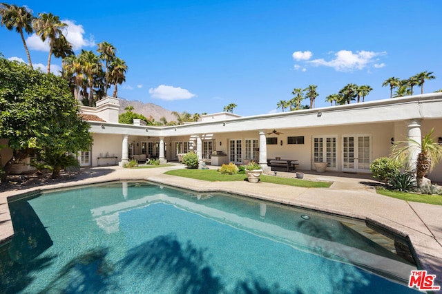 view of swimming pool with french doors, a patio, and ceiling fan