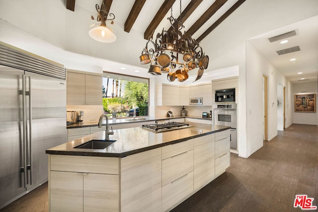 kitchen with sink, a center island, dark hardwood / wood-style floors, a chandelier, and appliances with stainless steel finishes