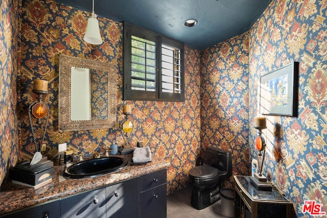 bathroom with tile patterned flooring, vanity, and toilet