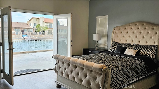 bedroom featuring access to exterior, hardwood / wood-style floors, and multiple windows