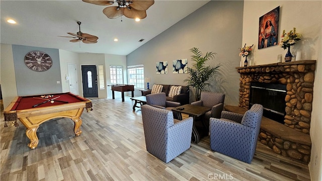 recreation room with pool table, light wood-type flooring, ceiling fan, a fireplace, and high vaulted ceiling