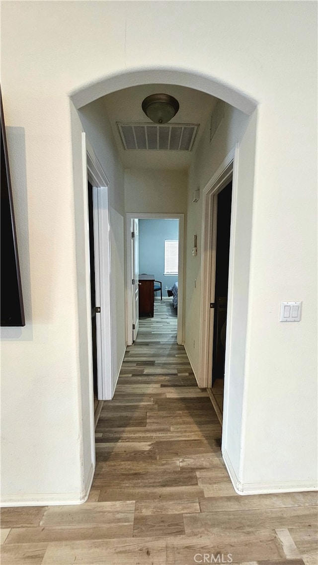 hallway with hardwood / wood-style flooring