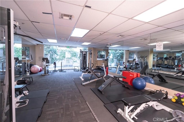 exercise room with carpet flooring and a drop ceiling