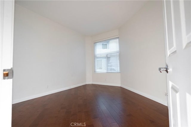 spare room featuring dark wood-type flooring