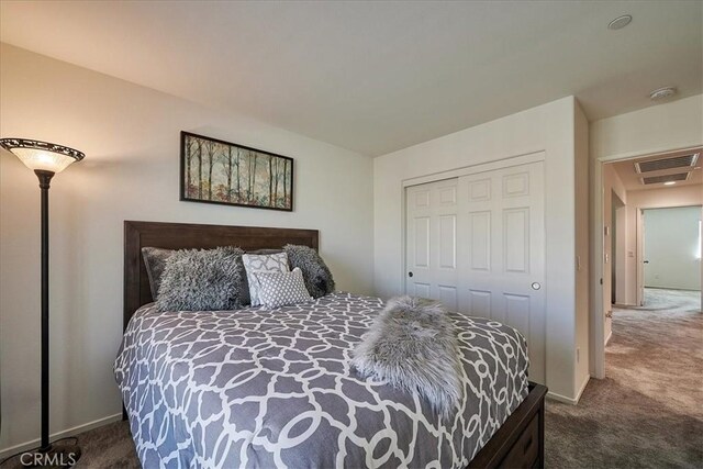 bedroom with dark carpet and a closet