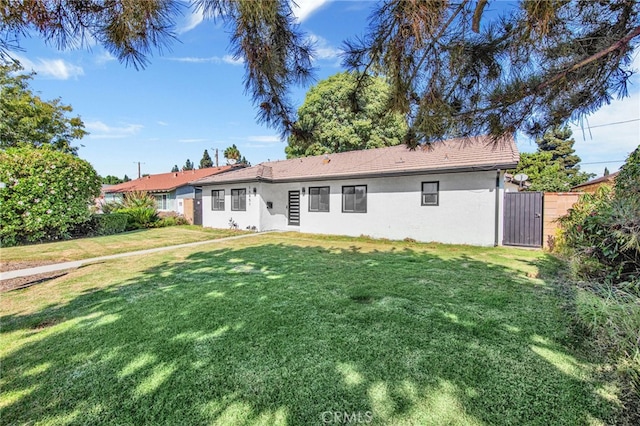 back of house featuring a lawn