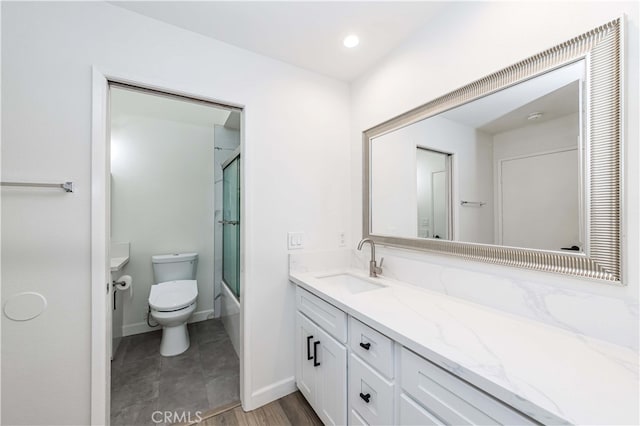 full bathroom featuring vanity, toilet, wood-type flooring, and shower / bath combination with glass door