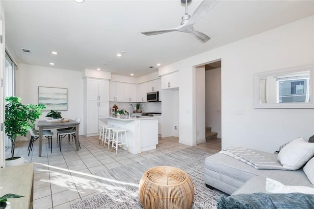 living room with ceiling fan and light tile patterned floors