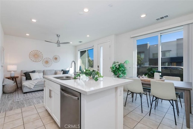 kitchen with white cabinetry, sink, ceiling fan, stainless steel dishwasher, and a kitchen island with sink