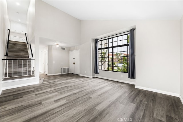 unfurnished living room featuring hardwood / wood-style flooring and high vaulted ceiling