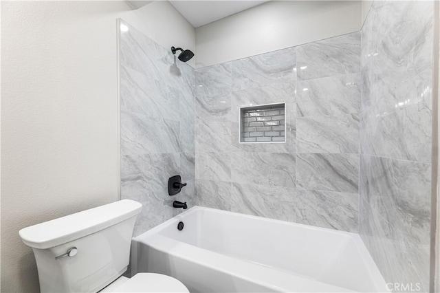 bathroom with toilet and tiled shower / bath