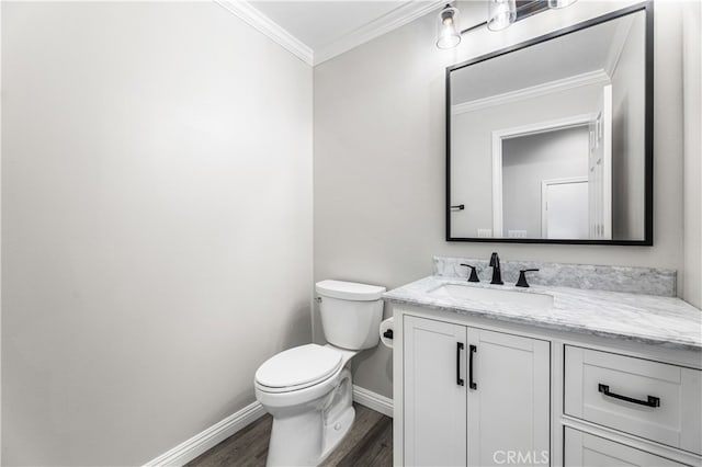 bathroom featuring toilet, ornamental molding, vanity, and hardwood / wood-style floors