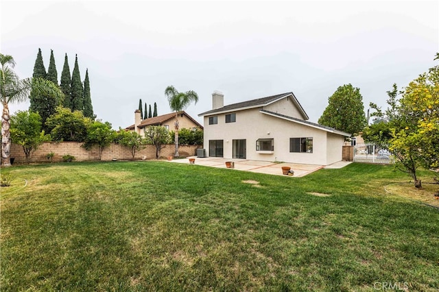 back of property with central AC unit, a patio, and a lawn