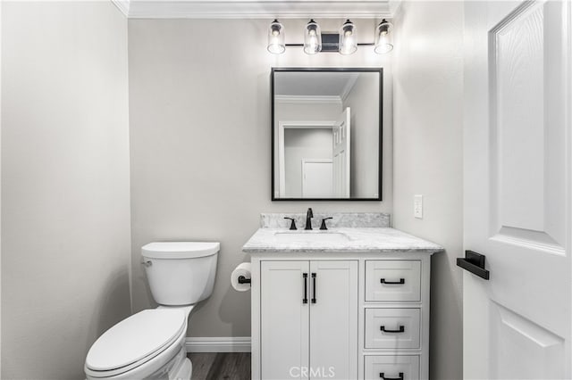 bathroom featuring toilet, crown molding, hardwood / wood-style floors, and vanity