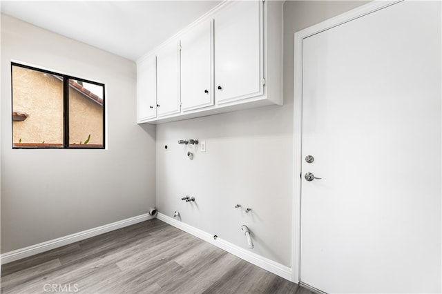 clothes washing area featuring hookup for a washing machine, cabinets, gas dryer hookup, and light wood-type flooring