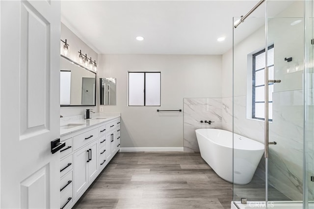 bathroom with vanity, hardwood / wood-style floors, and plus walk in shower